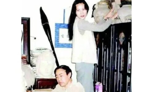 1997年，贾平凹和妻子郭梅站合影，墙上挂着一支巨大的毛笔最显眼-贾平凹的主要作品